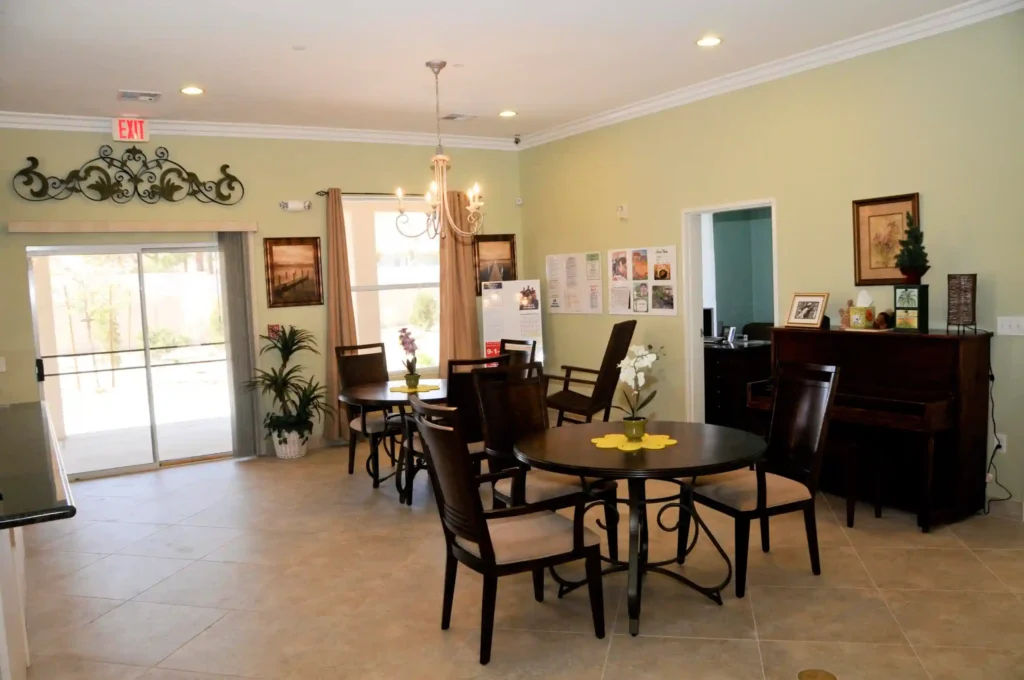 A dining room image in which some chairs and two tables and other things like that at NV Memory Care