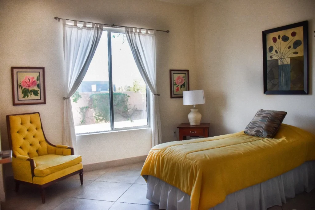 A room with a yellow chair and memory care amenities.