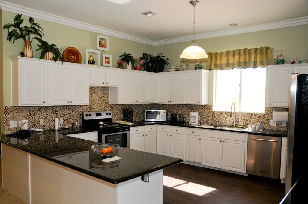 A kitchen with white cabinets and black counter tops designed for a senior lifestyle.