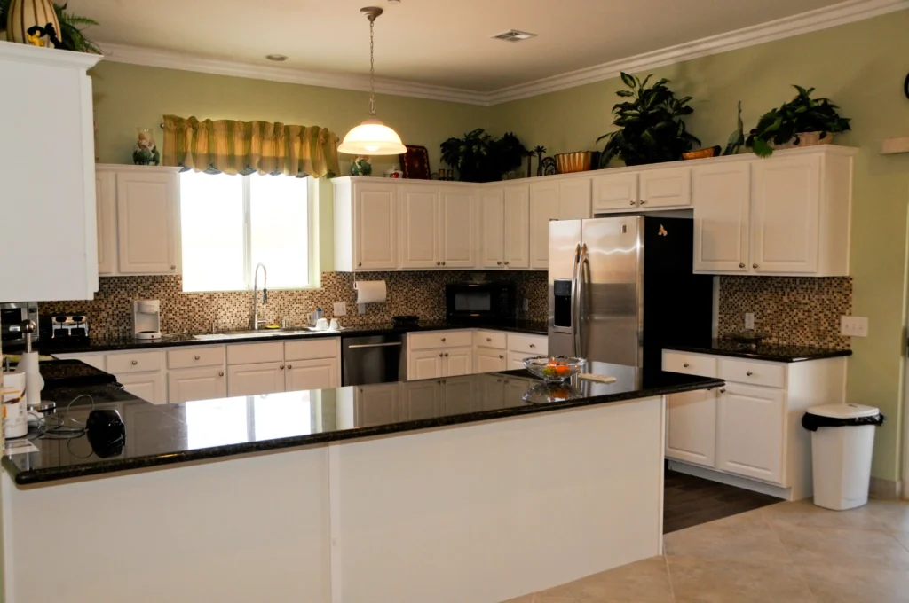 A kitchen with white cabinets and black counter tops is available at the Elderly Care Center.