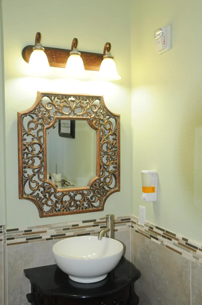 A bathroom at an Assisted Living center equipped with a sink and mirror.